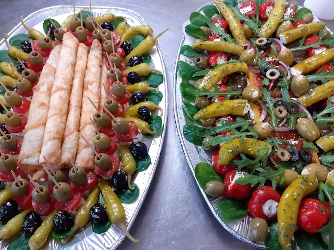 Zwei festlich angerichtete Antipasti-Platten mit Oliven, gefüllten Paprika und Börek